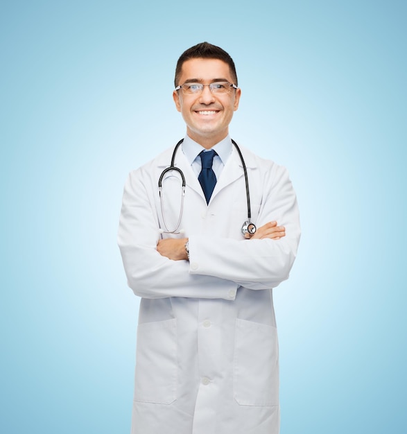 concept de soins de santé, de profession, de personnes et de médecine - médecin de sexe masculin souriant en blouse blanche sur fond bleu