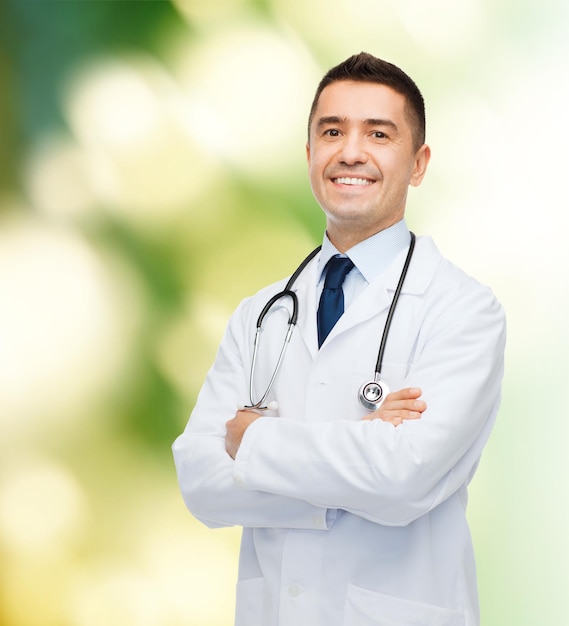 concept de soins de santé, de profession, de personnes et de médecine - médecin de sexe masculin souriant en blouse blanche sur fond vert