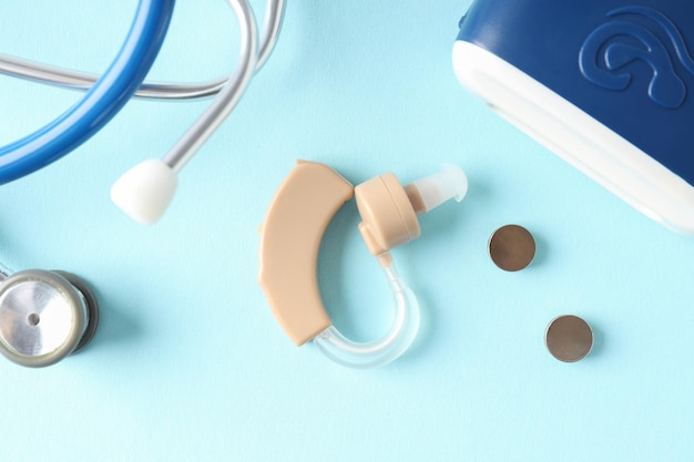Concept de soins de santé avec prothèse auditive sur fond bleu