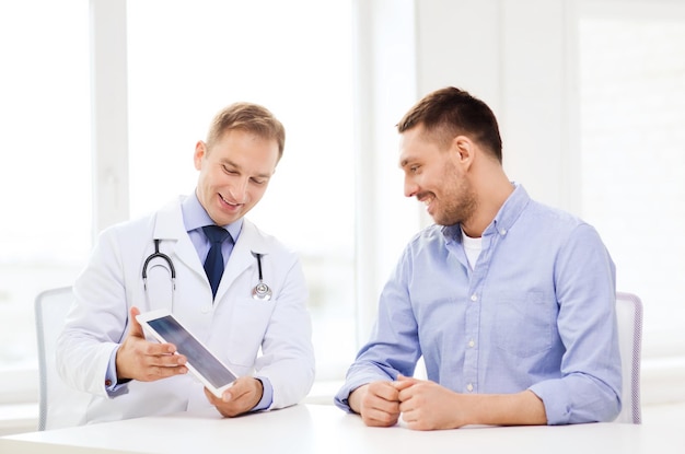 concept de soins de santé, de technologie et de médecine - médecin souriant avec ordinateur tablette et patient à l'hôpital