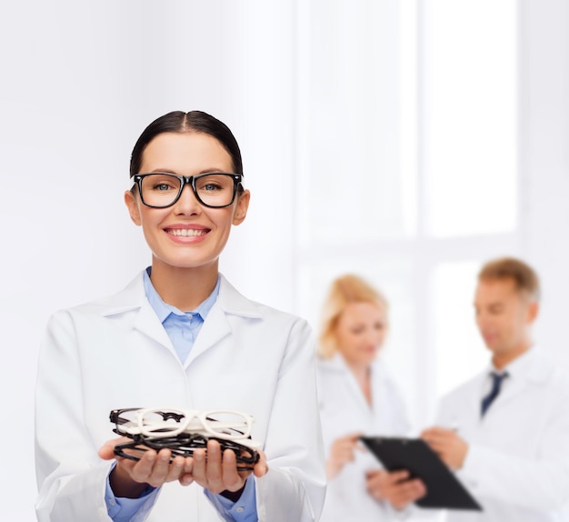 concept de soins de santé, de vision et de médecine - femme médecin souriante avec des lunettes