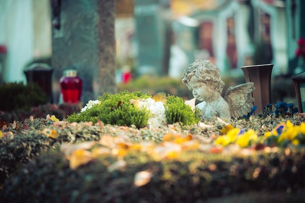 Photo concept de souvenir ange blanc sur une tombe fleurs