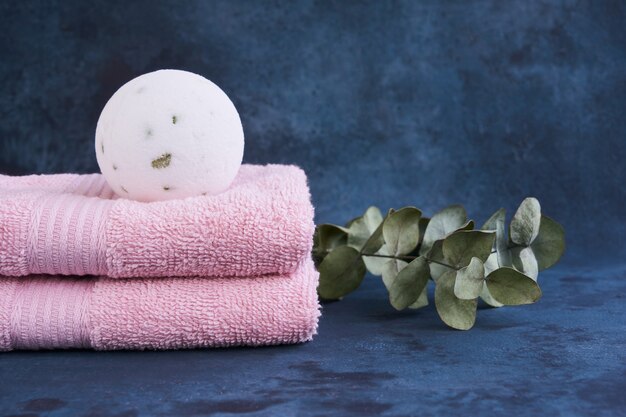 Concept de SPA. Bombes de bain et deux serviettes roses à la lumière.