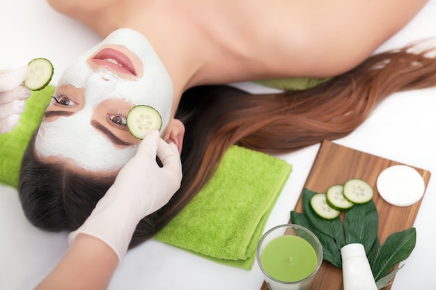 Concept spa. Jeune femme avec masque facial nutritif dans un salon de beauté, gros plan