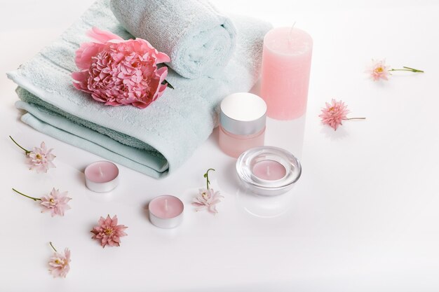 Concept de spa à la Saint-Valentin, jour d'anniversaire, pivoine rose, bougies, serviettes bleues, fleurs. Fond de printemps ou d'été