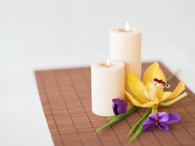 concept spa, santé et beauté - bougies, fleurs d'orchidées et d'iris sur tapis de bambou