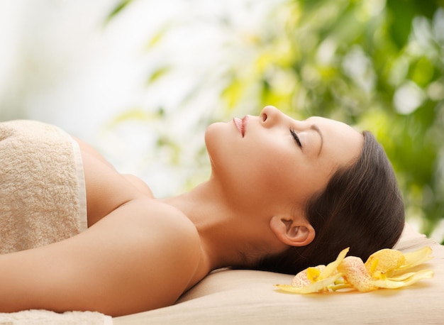 concept de spa et vacances - femme au spa allongée sur le bureau de massage