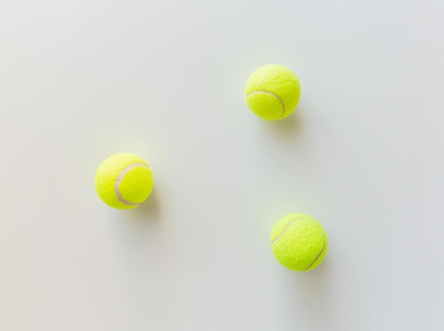 concept sport, fitness, jeu et objets - gros plan de trois balles de tennis jaunes