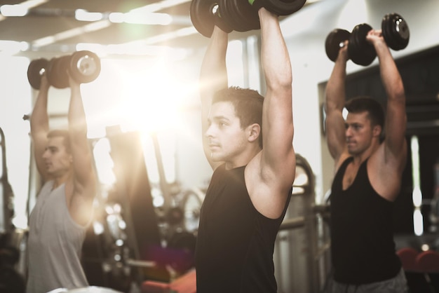 concept de sport, de fitness, de style de vie et de personnes - groupe d'hommes avec des haltères dans la salle de gym