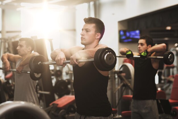 concept de sport, de fitness, de style de vie et de personnes - groupe d'hommes avec des haltères dans la salle de gym