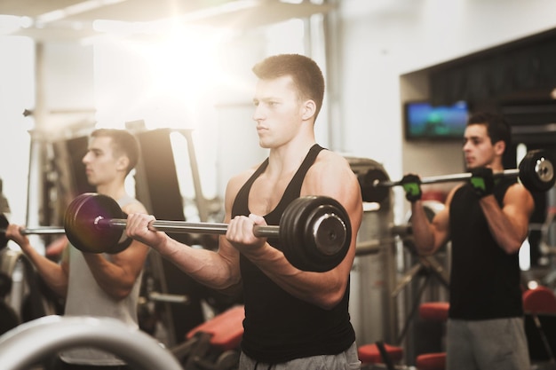 concept de sport, de fitness, de style de vie et de personnes - groupe d'hommes avec des haltères dans la salle de gym