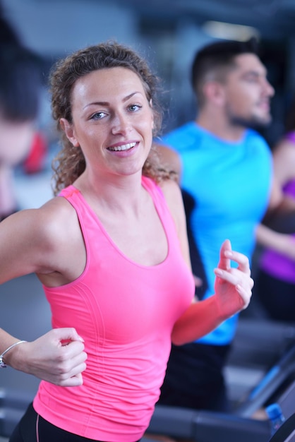 Concept de sport, fitness, style de vie, technologie et personnes - femme souriante exerçant sur tapis roulant dans la salle de gym