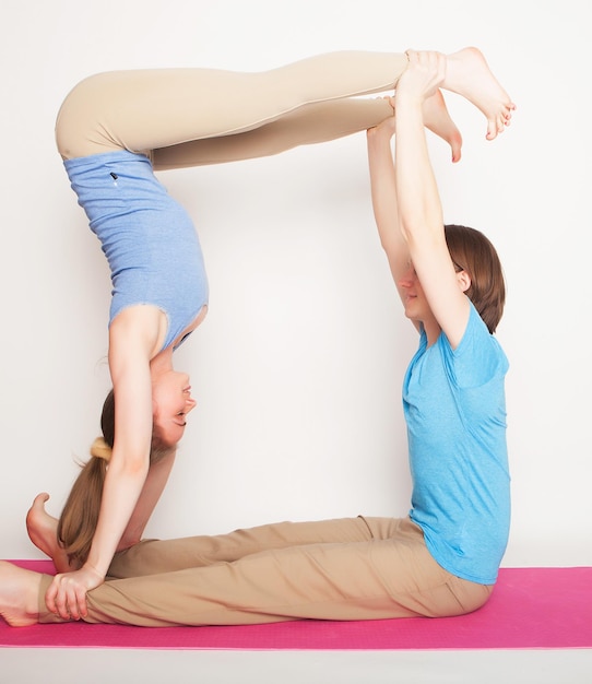 Concept de sport et de personnes de style de vie Jeune couple dans la pose de yoga sur fond blanc