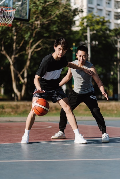 Concept de sports et de loisirs deux joueurs de basket masculins appréciant de jouer au basket ensemble