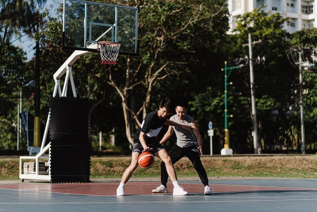 Concept de sports et de loisirs deux joueurs de basket masculins appréciant de jouer au basket ensemble