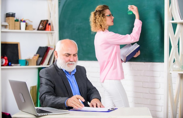 Photo concept stem homme professeur barbu enseignant à un étudiant étude d'un étudiant activité éducative éducateur et étudiant en classe fille avec bloc-notes près du tableau lycée enseignement universitaire