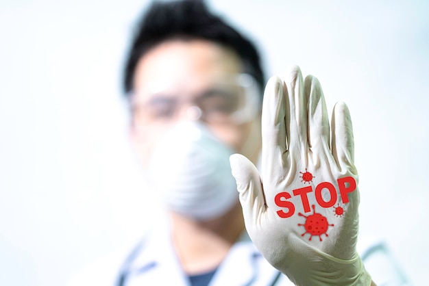 Le concept Stop covid-19 le médecin masculin fait un panneau d'arrêt pour arrêter le virus à la main