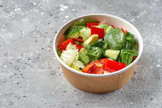 Le concept de street food, plats à emporter. Salade originale traditionnelle d'avocat, tomates, concombres, livraison de nourriture.