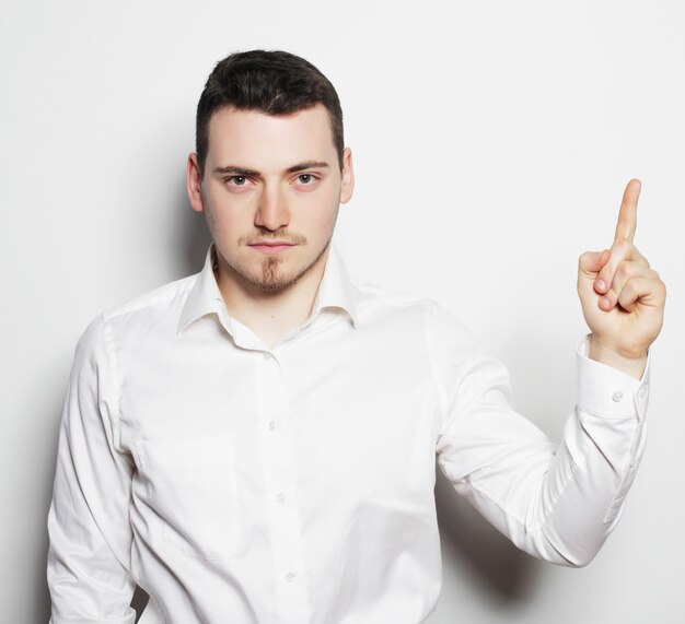 Photo concept de style de vie, d'affaires et de personnes: homme d'affaires pointant vers le haut du doigt. isolé sur un espace blanc /