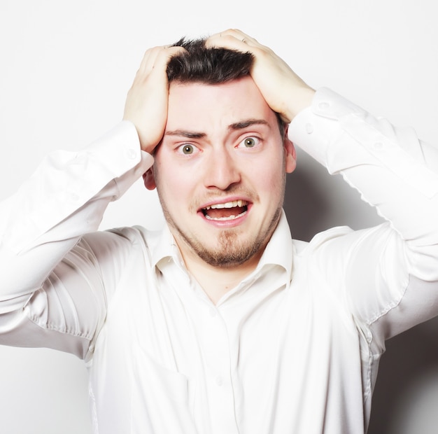 Concept de style de vie, d'affaires et de personnes : jeune employé de bureau fou de stress criant isolé sur blanc