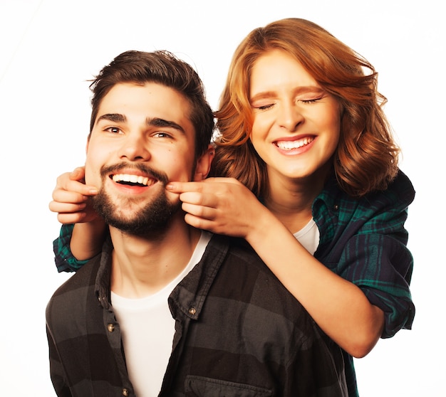 concept de style de vie, de bonheur et de personnes : couple d'amoureux heureux. Jeune homme ferrouillant sa petite amie. Studio tourné sur fond blanc. Photos spéciales de tonification à la mode.