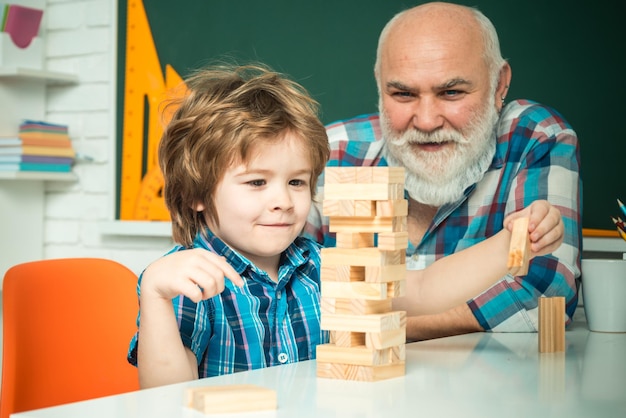 Concept de style de vie de famille de bonheur Trois générations différentes d'âge grand-père et fils enfant ensemble Joli garçon heureux jouant à Jenga avec son grand-père