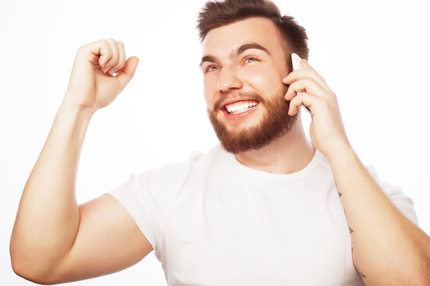 Concept de style de vie, de technologie et de personnes : homme gai au téléphone avec le poing levé recevant de bonnes nouvelles.