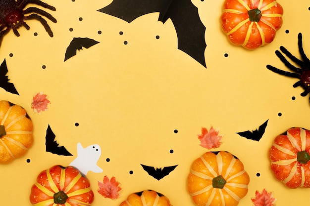 Concept de symbole Halloween Scary smile citrouille avec araignée et chauve-souris avec fantôme sur fond jaune