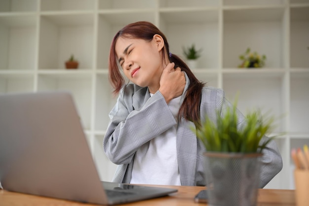 Concept de syndrome de bureau Femme d'affaires asiatique millénaire ayant une douleur aux épaules