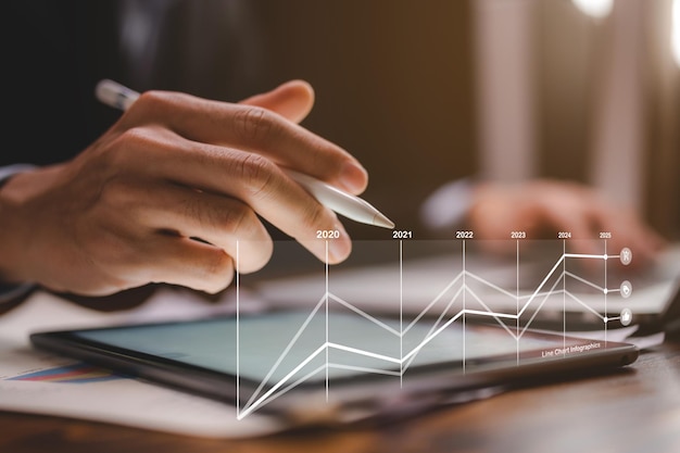 Concept de technologie de communication d'entreprise homme d'affaires utilisant un stylo numérique pour travailler sur un appareil d'écran d'ordinateur tablette dans un document de marketing en ligne de travail de bureau moderne sur la table de bureau