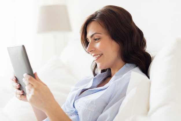 concept de technologie, d'internet et de personnes - femme souriante avec ordinateur tablette pc à la maison