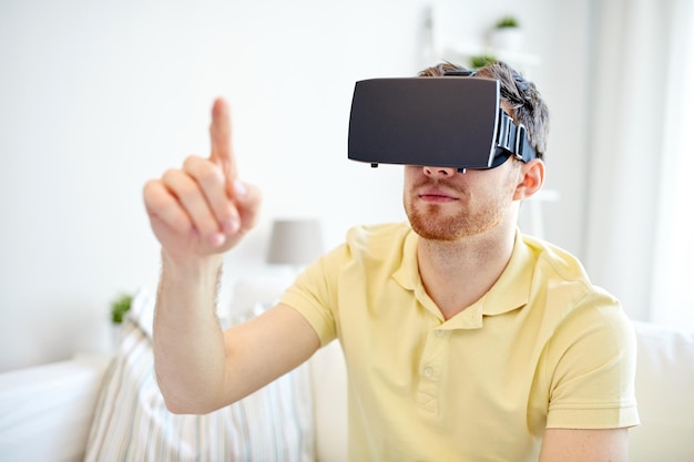 concept de technologie, de jeu, de divertissement et de personnes - jeune homme avec un casque de réalité virtuelle ou des lunettes 3d jouant à un jeu vidéo