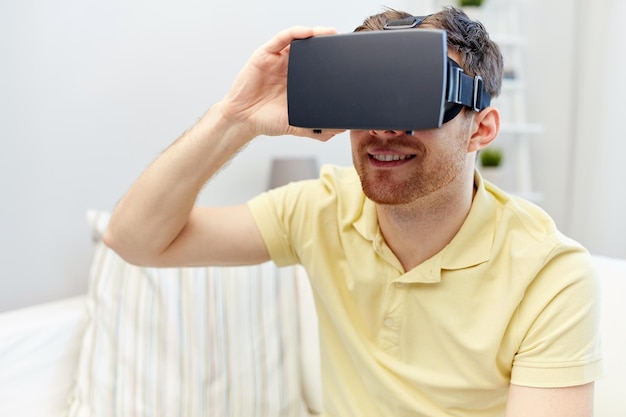 concept de technologie, de jeu, de divertissement et de personnes - jeune homme heureux avec un casque de réalité virtuelle ou des lunettes 3d jouant à un jeu vidéo