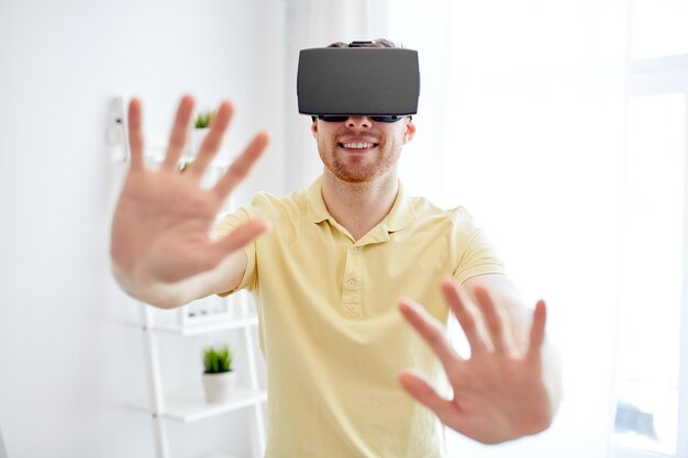 concept de technologie, de jeu, de divertissement et de personnes - jeune homme heureux avec un casque de réalité virtuelle ou des lunettes 3d jouant à un jeu vidéo