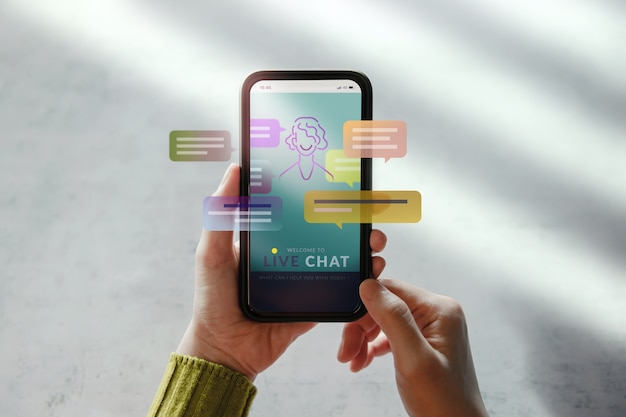 Concept De Technologie Livechat. Client Utilisant Un Téléphone Portable Pour Converser Avec Une Intelligence Artificielle. Assistant Virtuel Pour Les Informations De Support Client