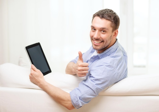 concept de technologie, de maison et de style de vie - homme souriant travaillant avec un ordinateur tablette à la maison montrant les pouces vers le haut