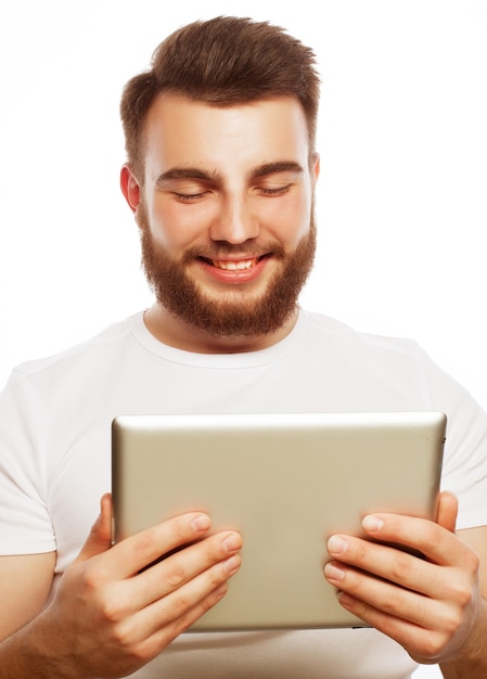 Concept De Technologie Et De Mode De Vie : Jeune Homme Portant Un T-shirt Blanc à L'aide D'un Ordinateur Tablette - Isolé Sur Une Surface Blanche