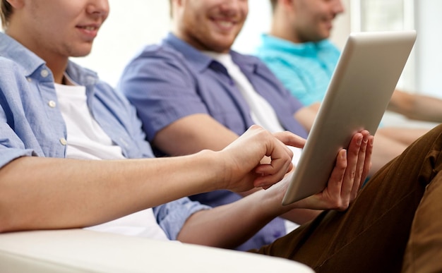 concept de technologie et de personnes - gros plan d'amis heureux avec des ordinateurs tablettes à la maison