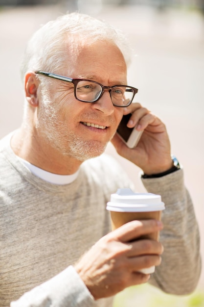 concept de technologie, de personnes, de style de vie et de communication - homme senior heureux appelant sur smartphone en ville