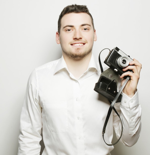 Concept de technologie, de personnes et de style de vie : jeune photographe sur fond blanc