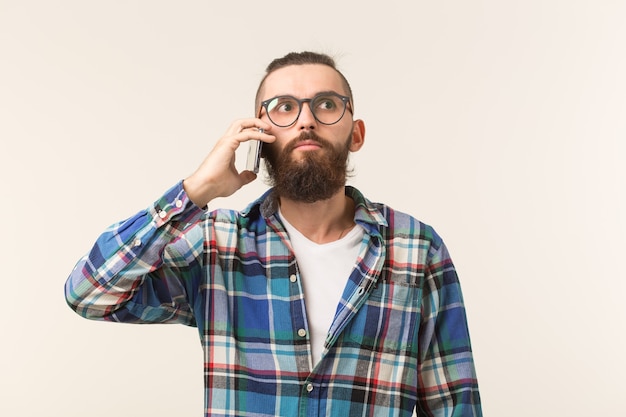 Concept de technologies, de mode et de personnes - Homme cool avec barbe à l'aide de téléphone sur un espace blanc