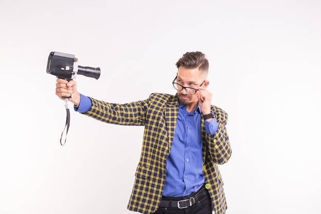 Concept de technologies, de photographie et de personnes - portrait d'un drôle de jeune homme brune prenant un selfie avec deux caméras sur fond blanc.