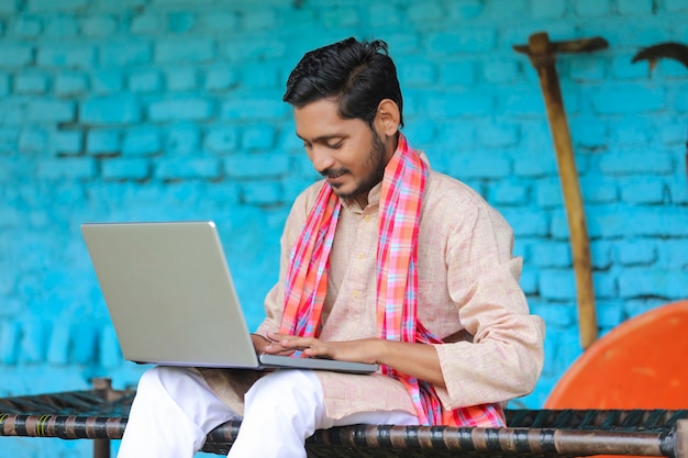 Concept technologique : agriculteur indien utilisant un ordinateur portable à la maison