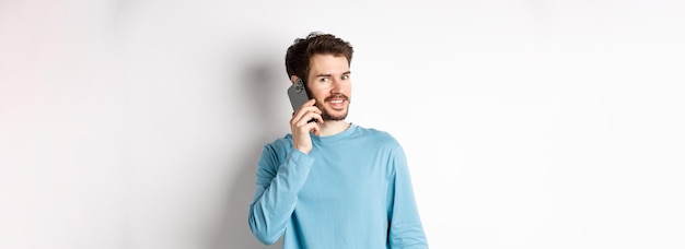 Concept technologique jeune modèle masculin parlant sur téléphone mobile appelant quelqu'un sur smartphone et smilin