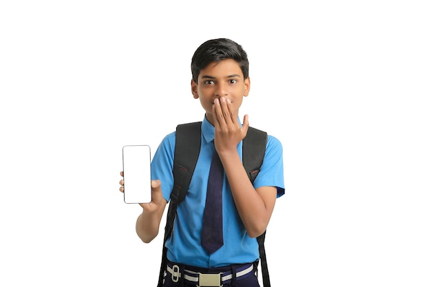 Concept technologique Mignon petit écolier indien montrant un smartphone