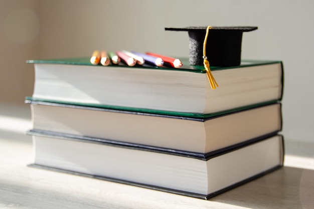 Concept de temps d'éducation et d'apprentissage Graduation cap sur une pile de livres avec des crayons de couleur