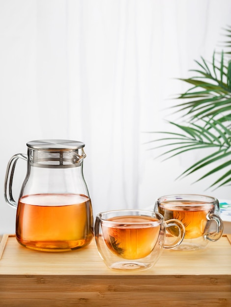 Photo concept de thé asiatique deux tasses de verre de thé et une théière