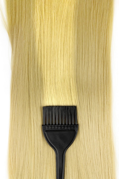 Concept de traitement d'extension de cheveux mourant ou colorant Longs cheveux blonds avec brosse de coloration des cheveux Matériaux d'extensions de cheveux et perruque cosmétique Outils professionnels pour la teinture