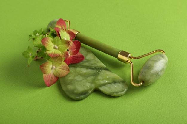 Concept de traitement liftant et tonifiant avec gua sha sur fond vert