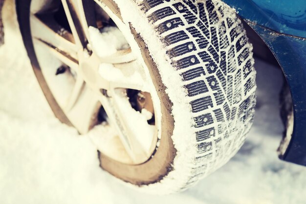 concept de transport, d'hiver et de véhicule - gros plan sur un pneu d'hiver de voiture